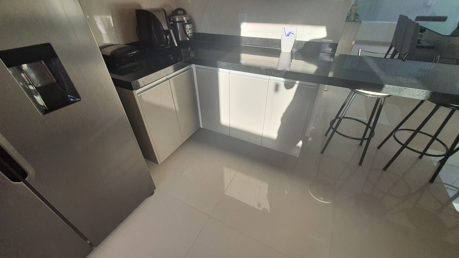 Cozinha com bancada escura e península